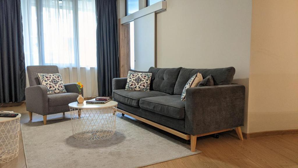 a living room with a gray couch and a table at Lux 1 Apartment with Free Parking in Plovdiv