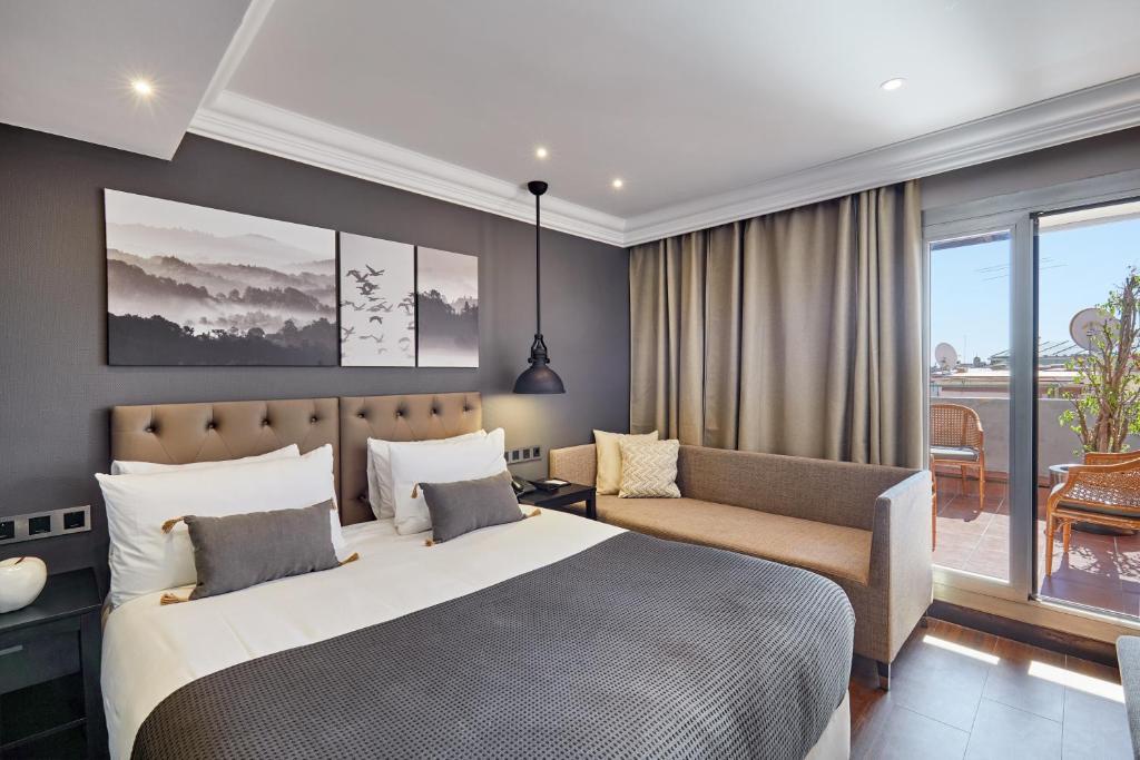 a bedroom with a large bed and a couch at Hotel Cortes Rambla in Barcelona
