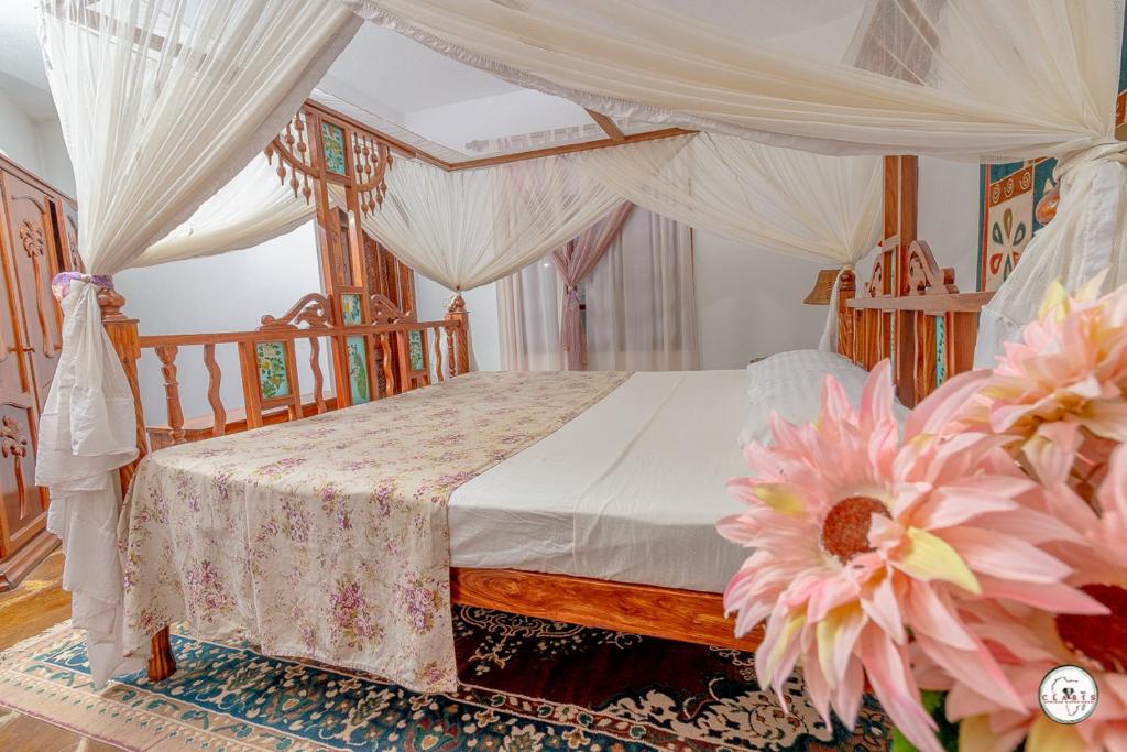 1 dormitorio con cama con dosel y cortinas blancas en Suite Two Rooms - Watamu en Watamu