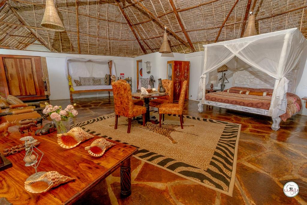 ein Wohnzimmer mit einem Bett und einem Tisch in der Unterkunft King Lion Room - Watamu in Watamu