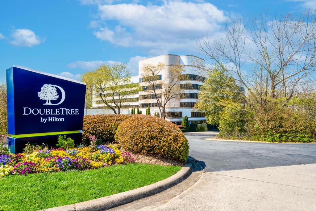 una señal frente a un edificio con flores en DoubleTree by Hilton South Charlotte Tyvola en Charlotte