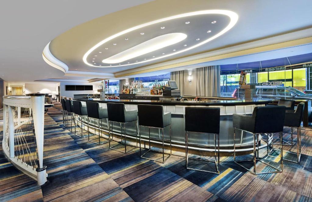 a bar with black chairs and a bar counter at New York Hilton Midtown in New York