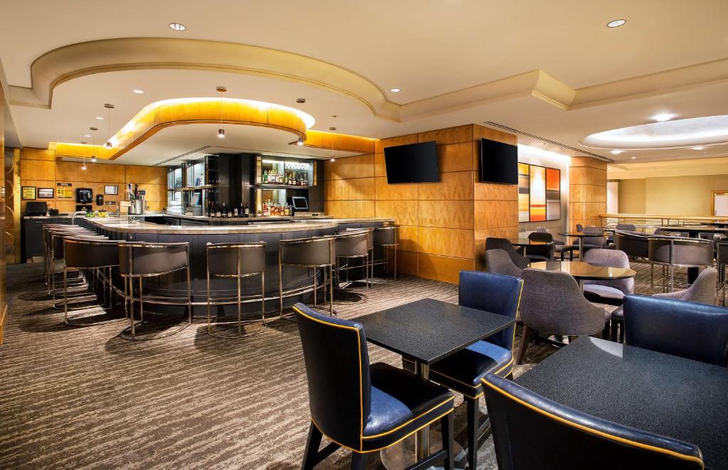 a restaurant with tables and chairs and a bar at New York Hilton Midtown in New York