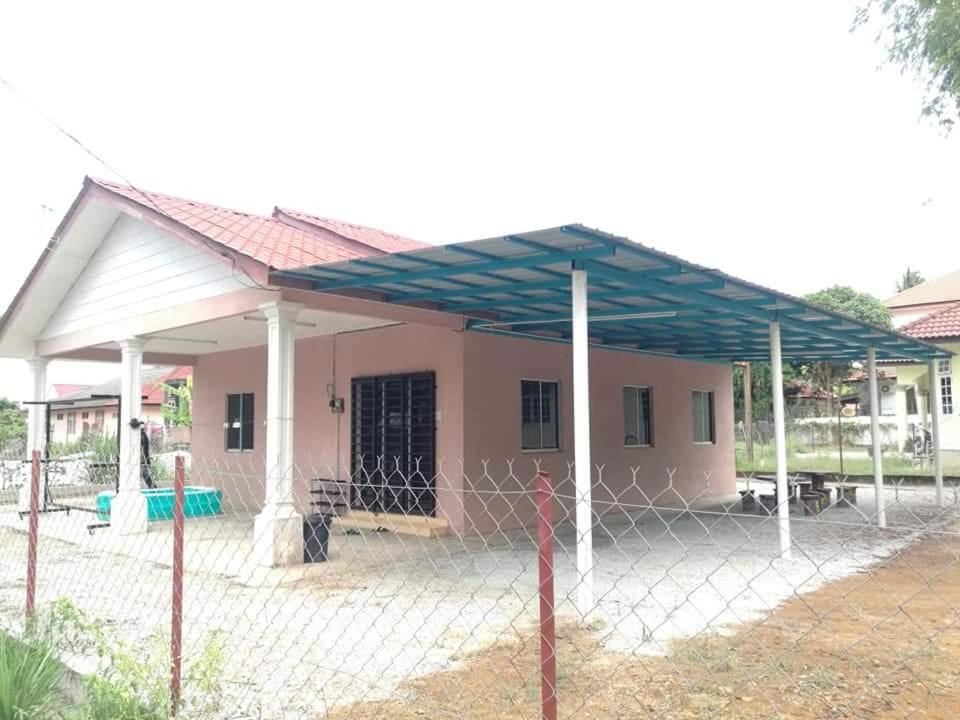 une petite maison avec une clôture devant elle dans l'établissement HOMESTAY IRAMA HATY BACHOK, à Bachok