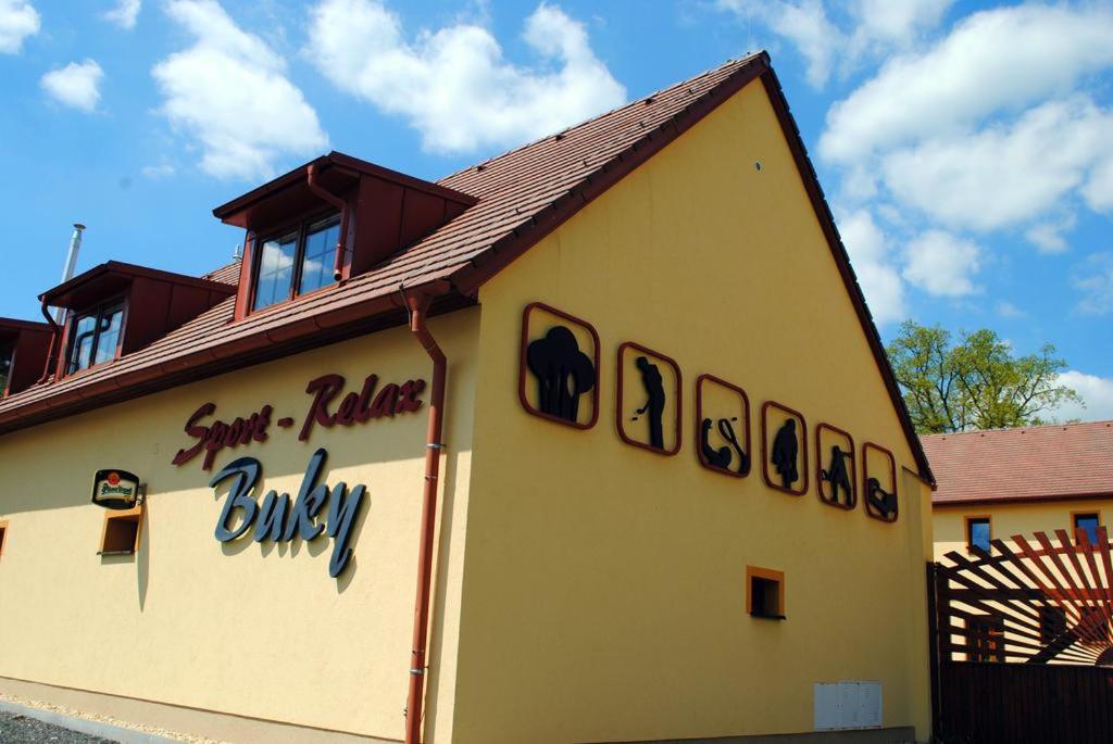 a building with a sign on the side of it at Sport - Relax Buky in Františkovy Lázně
