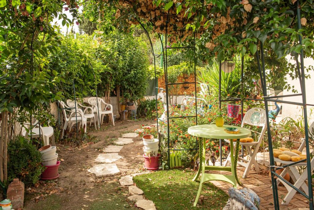 um jardim com uma mesa e cadeiras sob uma pérgola em Villa Marie Carmen em Rivesaltes