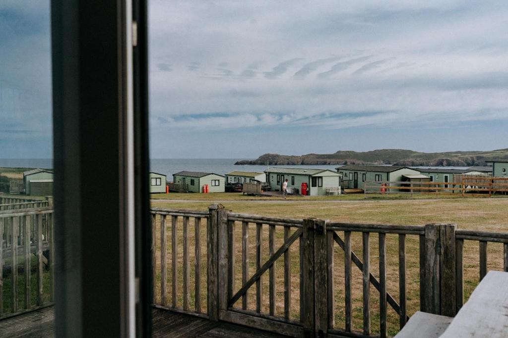a view from a window of a farm with houses at Caravan with sea views on the coast near St Davids in Pembrokeshire