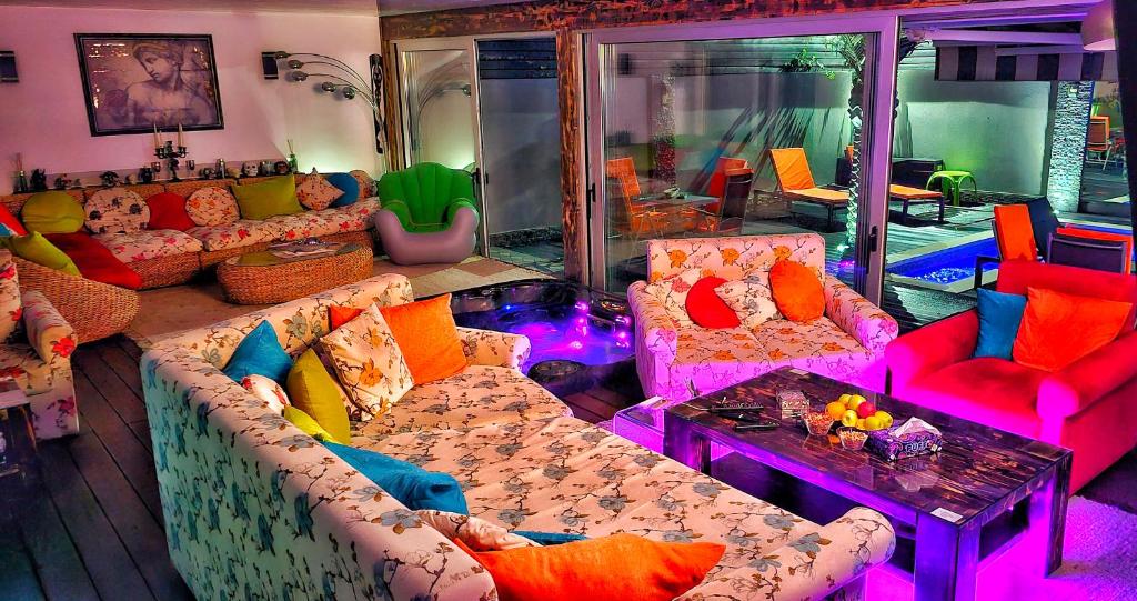 Villa RICH في تيميشوارا: غرفة معيشة مع أرائك ملونة وطاولة