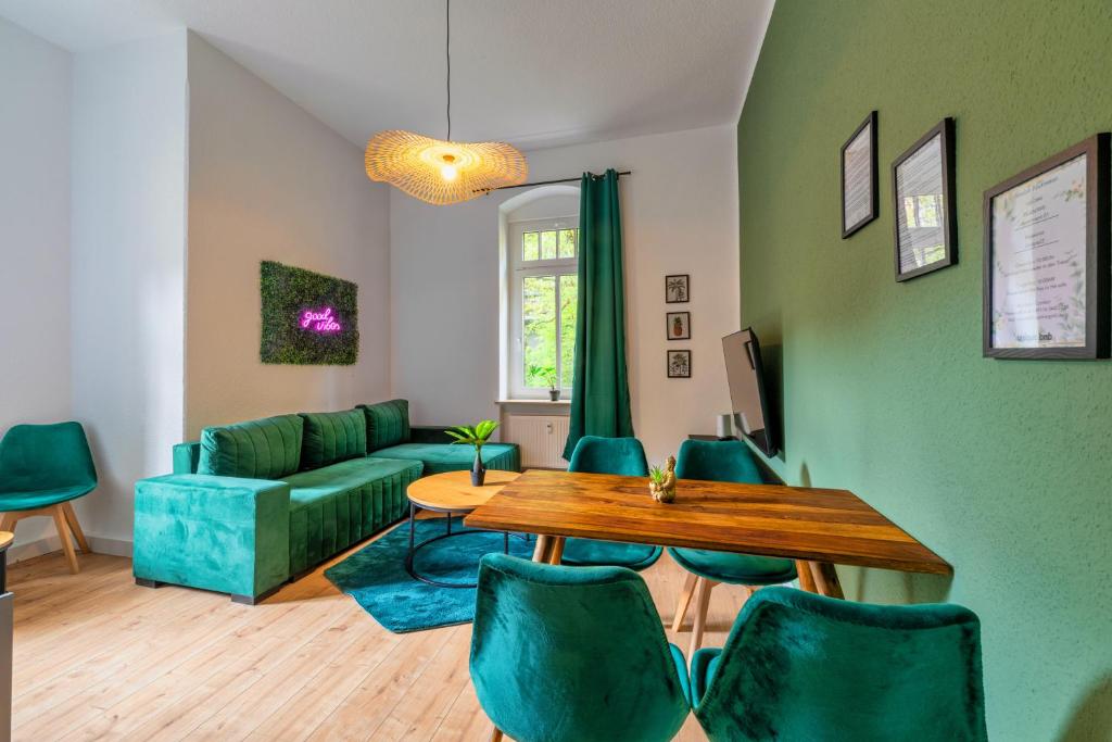 een woonkamer met een tafel en groene stoelen bij unique Malterstraße feel-good-home - Dresden in Dresden