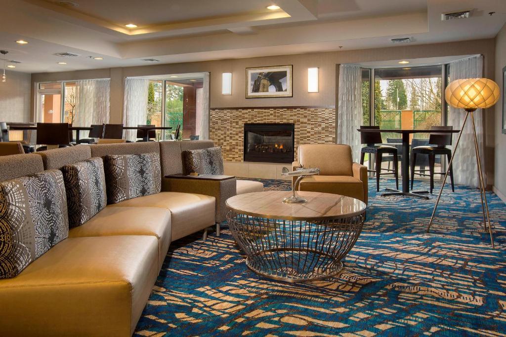 a hotel lobby with couches and a fireplace at Courtyard Seattle North / Lynnwood Everett in Lynnwood