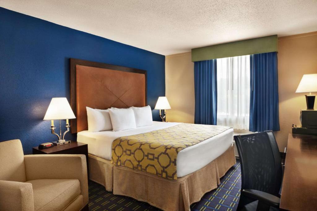 a hotel room with a large bed and a chair at Express Inn and Suites in Little Rock
