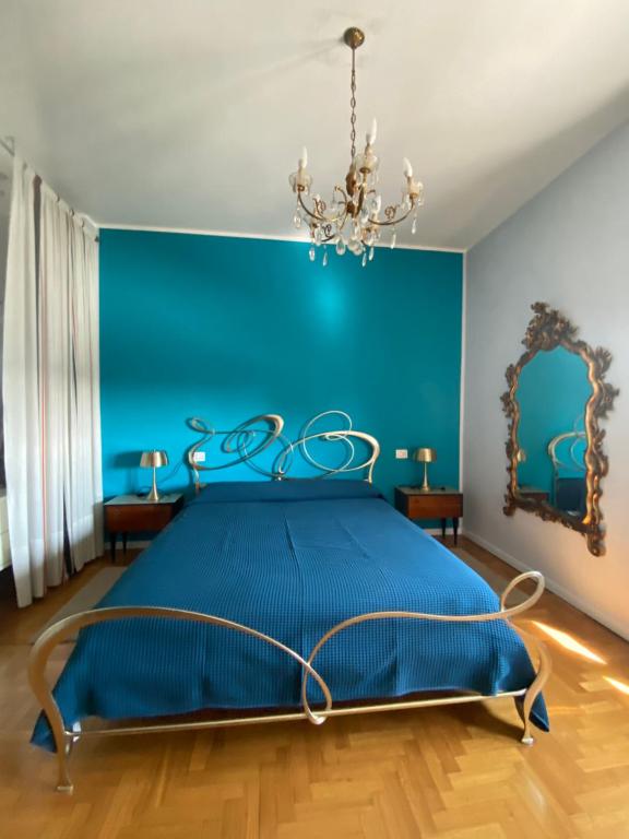 a blue bedroom with a bed and a chandelier at Giulia's Apartment in Milan Bicocca in Milan