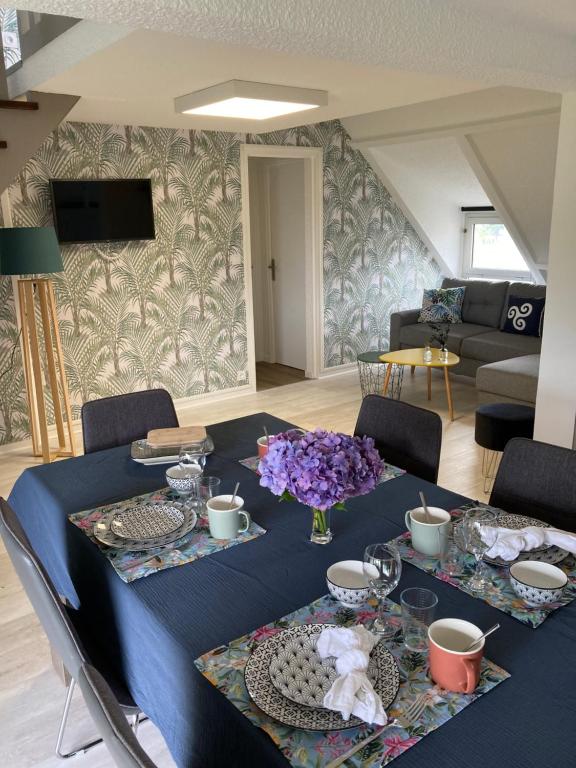 - une table bleue avec des fleurs dans le salon dans l'établissement Le Ty Refuge Terrasse WiFi Parking, à Carnac