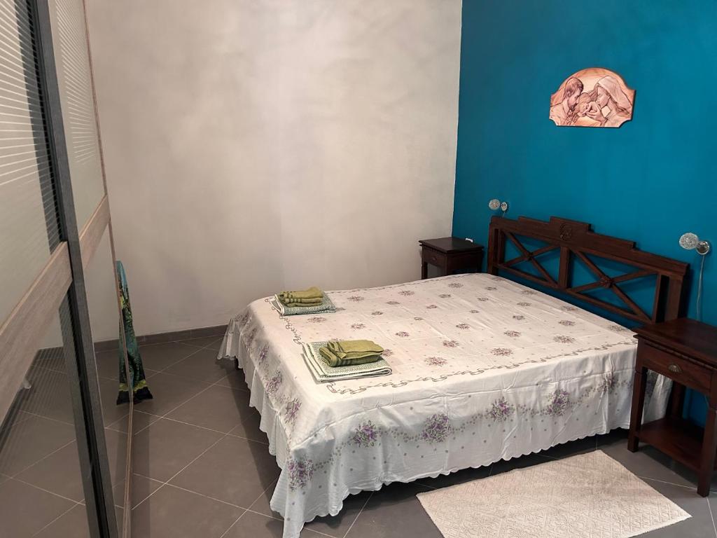 Casa vacanza I Pavoni في Campanedda: سرير صغير في غرفة بجدران زرقاء