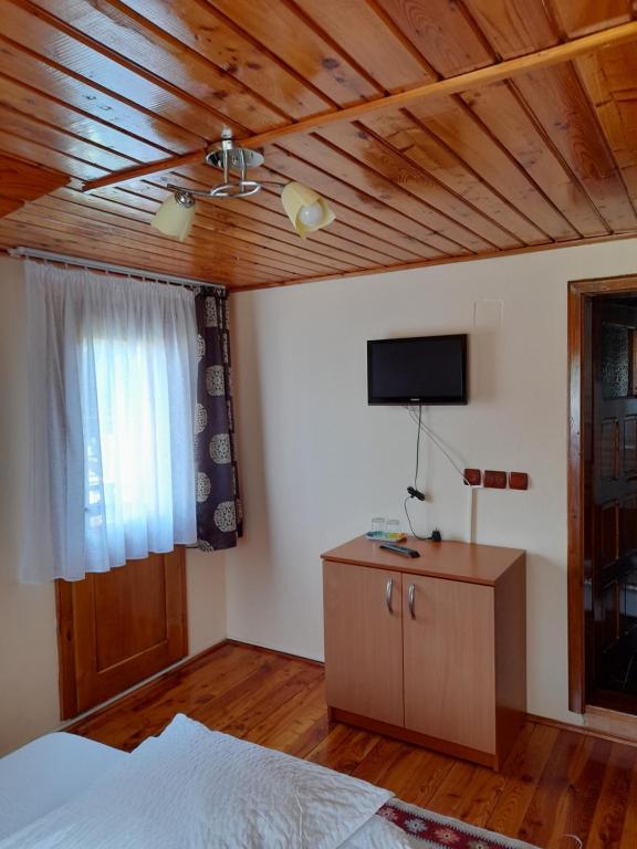 a bedroom with a bed and a flat screen tv at Cabana Med 2 in Arieşeni