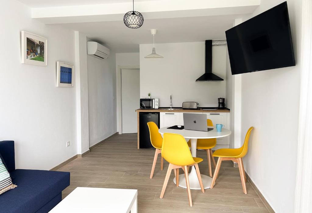 Apartamentos El Camino Resorts في كوبرسيز: غرفة معيشة مع طاولة وكراسي صفراء