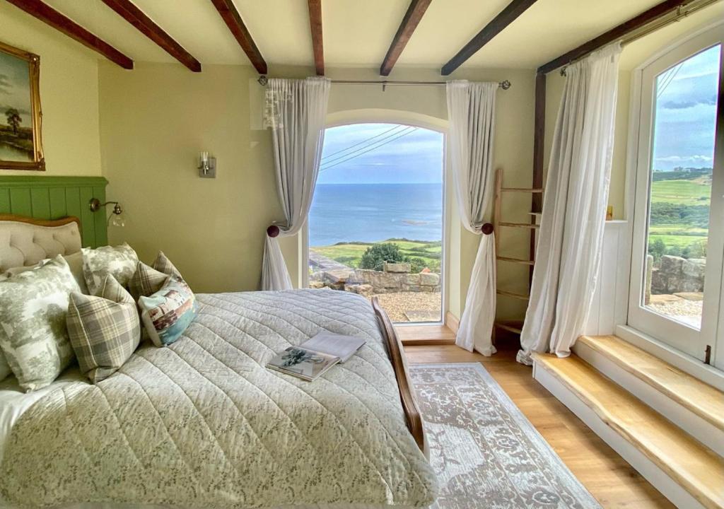 a bedroom with a bed and a large window at 1 Browcote Cottage in Ravenscar