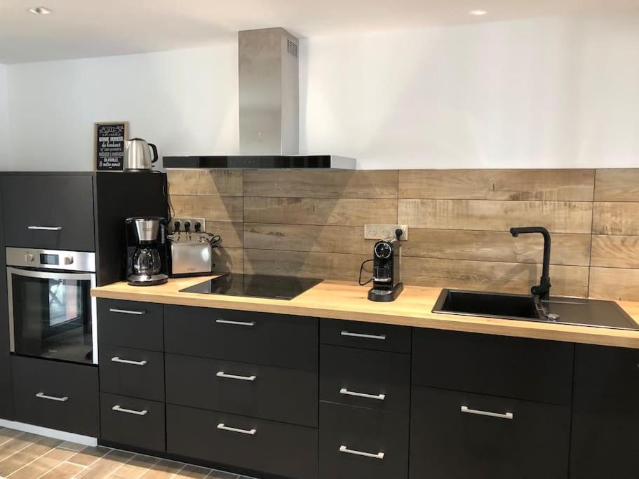 une cuisine avec un évier et une cuisinière four supérieur dans l'établissement Maison entièrement renovee, à Meyssac