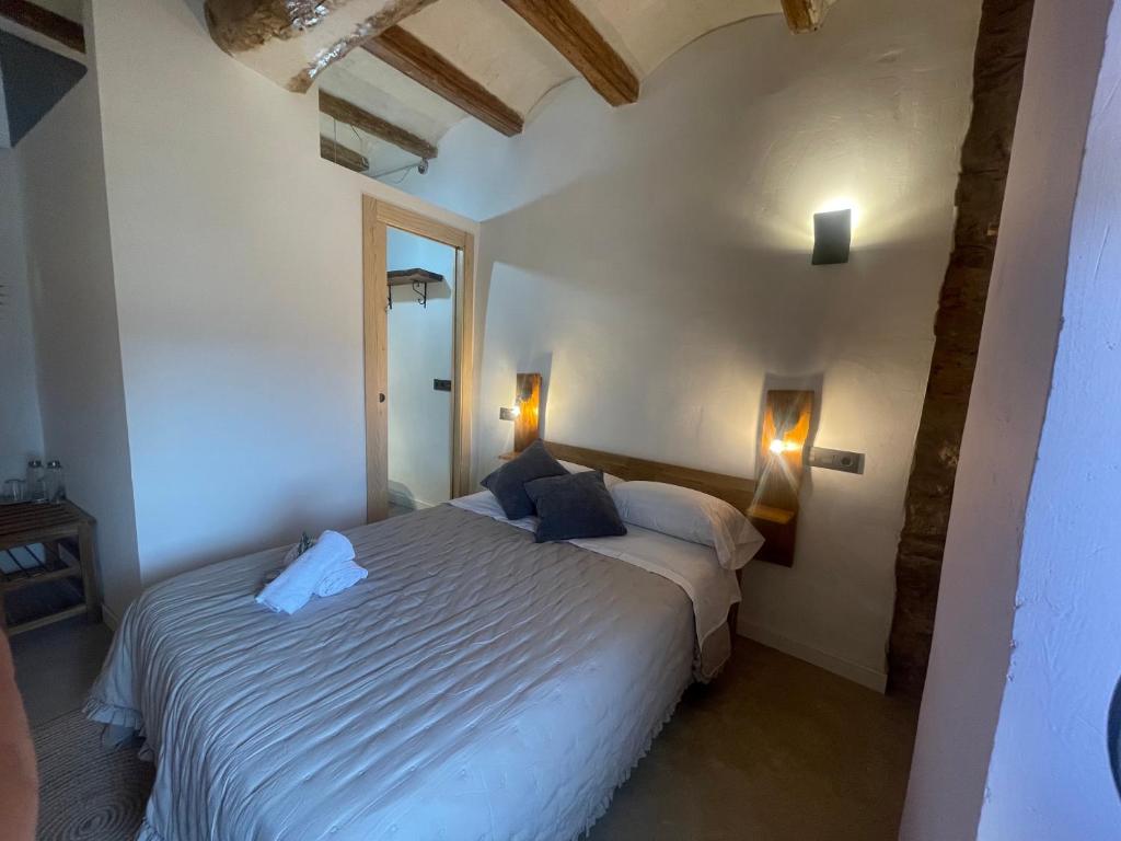 - une chambre avec un grand lit blanc dans l'établissement Castell de l'Aguda, à Torá de Rulbregos