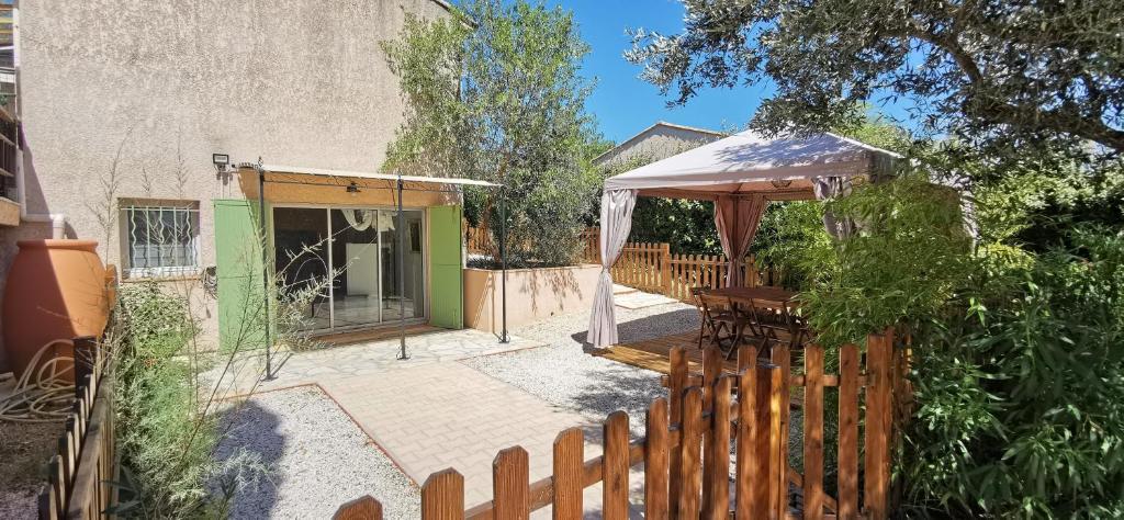 ein Haus mit einem Holzzaun und einem Pavillon in der Unterkunft PASSION DU VAR in Vidauban