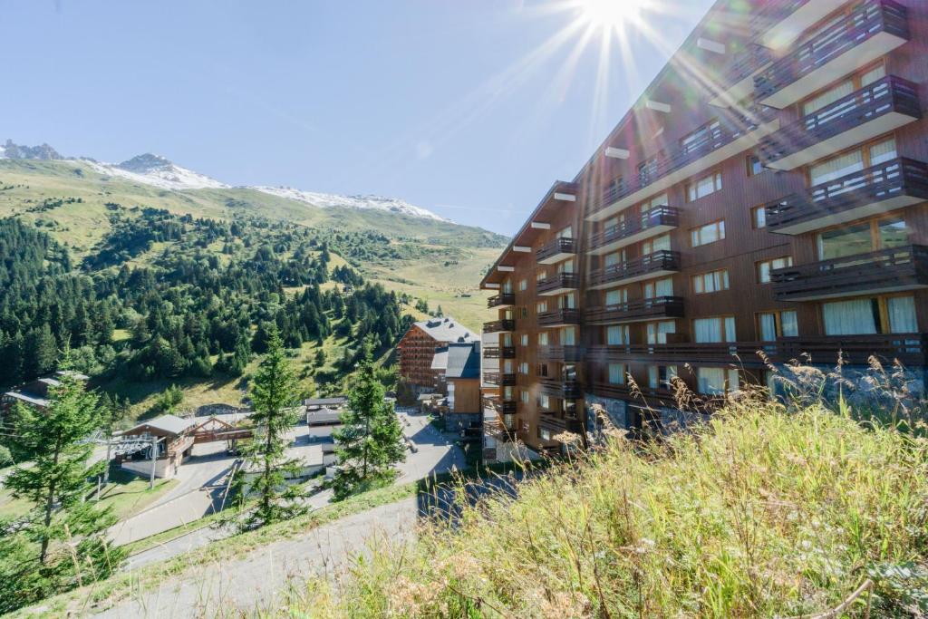an apartment building with a view of a mountain at le plein soleil méribel mottaret in Les Allues