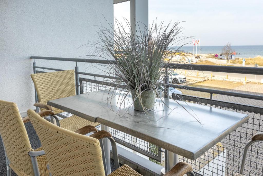 einen Tisch mit einer Topfpflanze auf einem Balkon in der Unterkunft Ostseeresidenz App 22 in Heiligenhafen