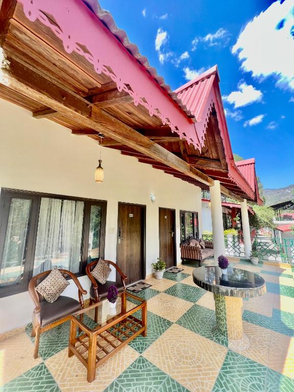 un patio di una casa con sedie e tavolo di Sea Hawk - Luxury Hill Resort 4 mins from Bhimtal Lake a Bhimtal