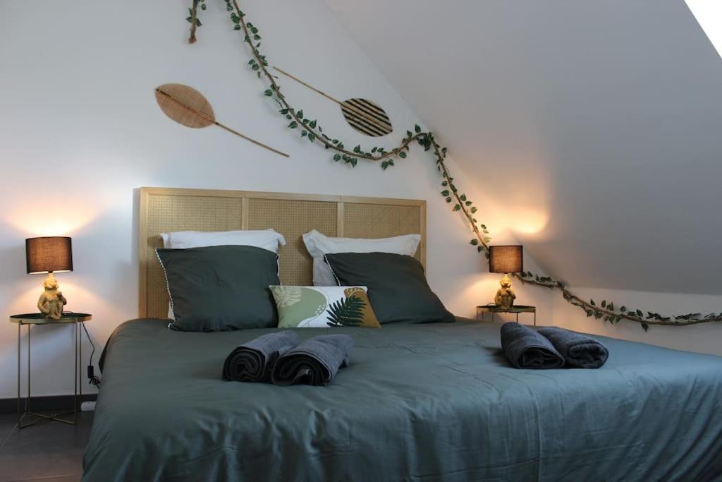1 cama con 2 almohadas y 2 lámparas en Jungle suite - moderne et spacieux, en Annecy