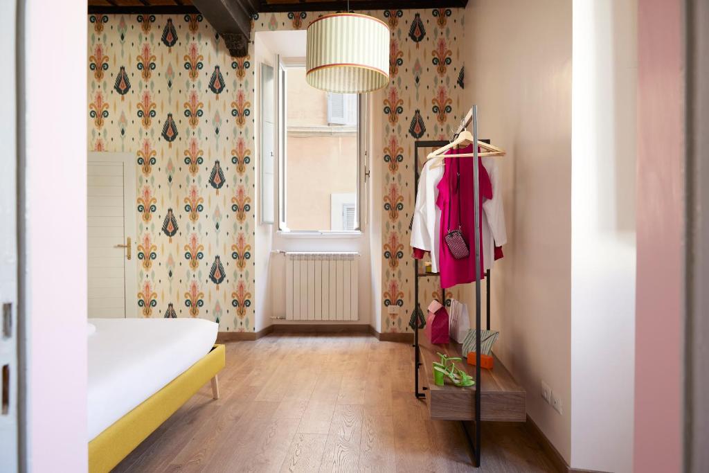 a room with a white couch and a pink shirt on a rack at Santa Maria della Quercia in Rome