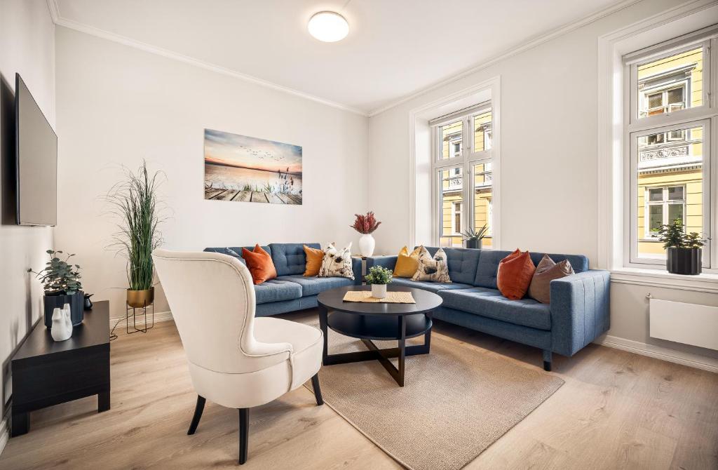 ein Wohnzimmer mit einem blauen Sofa und einem Tisch in der Unterkunft Rosen Apartment in Bergen