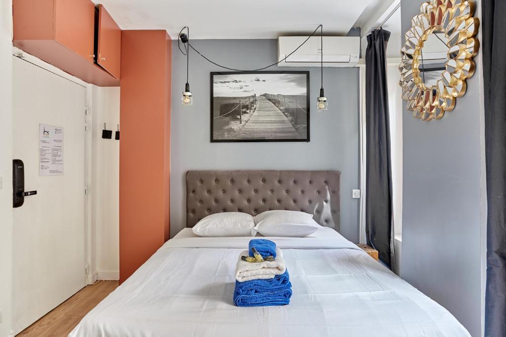 - une chambre avec un grand lit aux murs orange dans l'établissement Rent a Room - Residence Caire, Montorgueil, à Paris