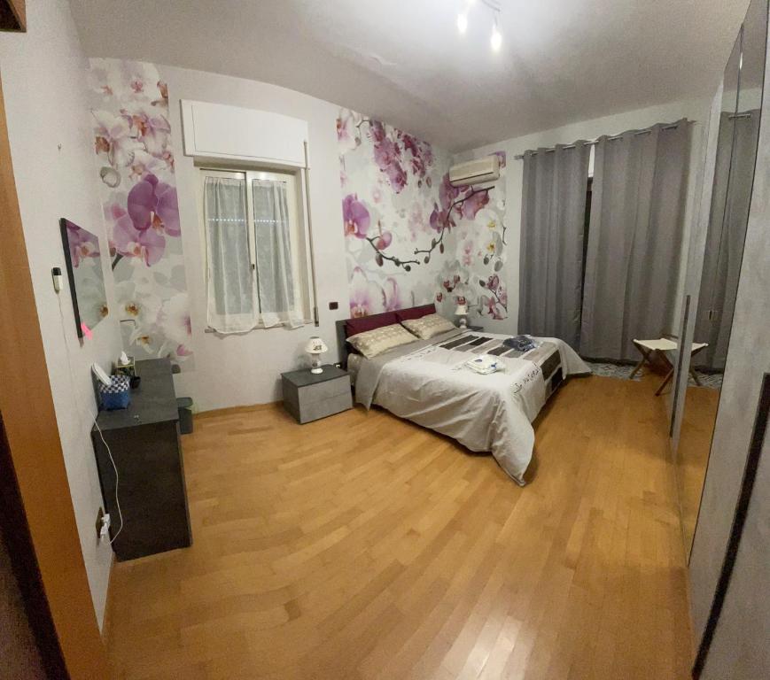 1 dormitorio con 1 cama y suelo de madera en B&b L’Attico e la Ballata, en Brusciano