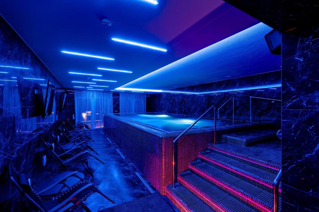 um quarto com luzes azuis e vermelhas e escadas em Diamond Panzió em Hajdúszoboszló