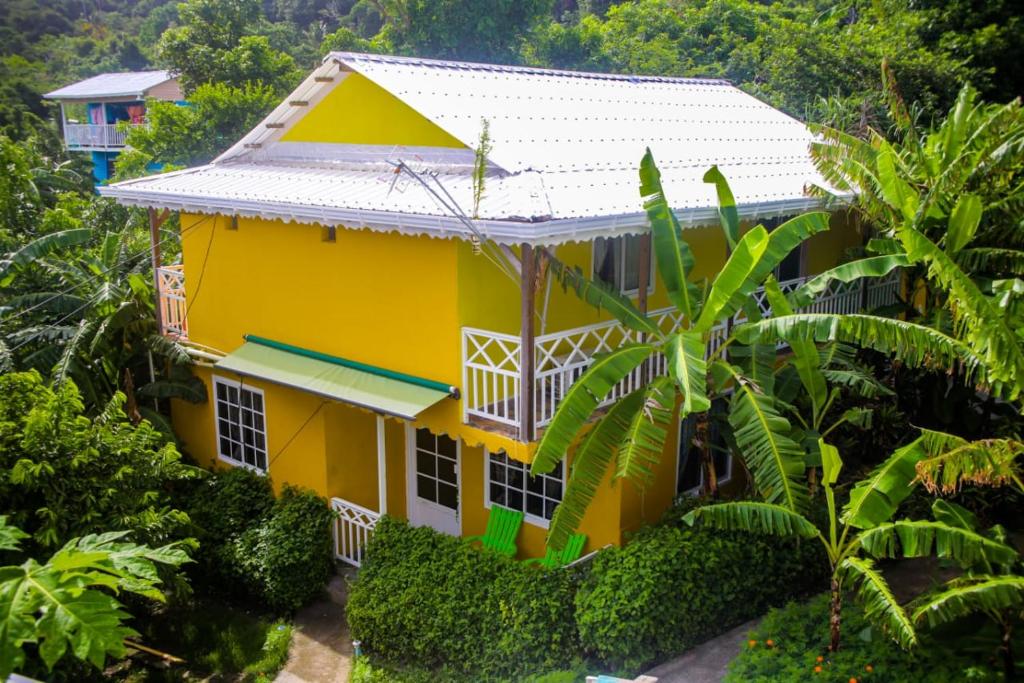 a yellow house with a white roof at Posada Hostel Adri in Providencia