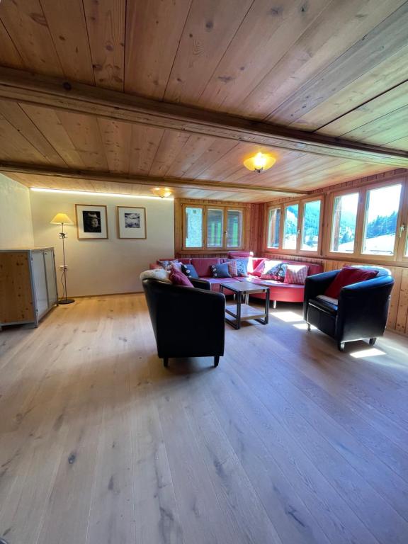 a large living room with couches and a table at Weissmies Lodge in Saas-Grund