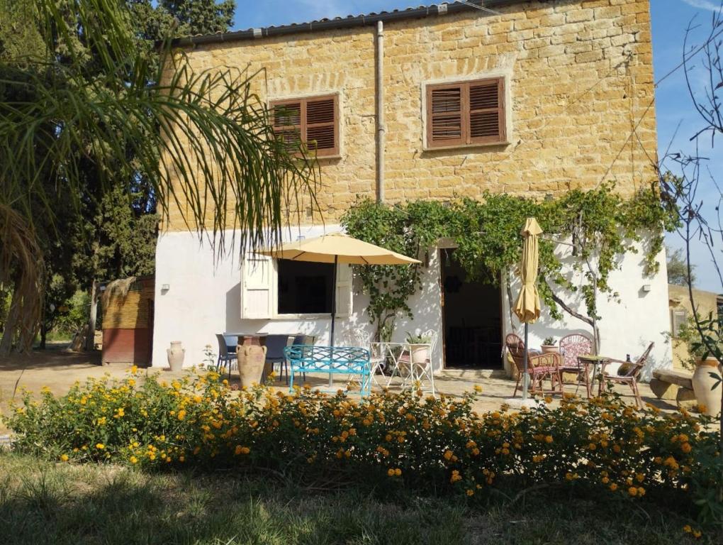 a house with a table and chairs and an umbrella at La Villa di Minerva in Agrigento