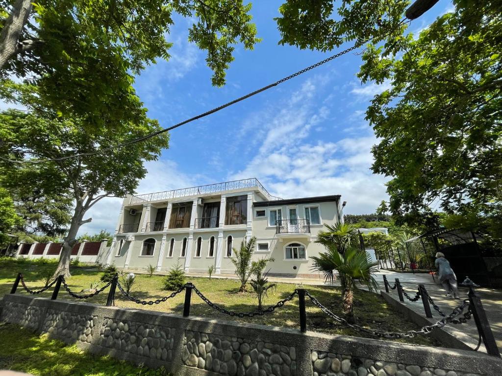 a white house with a fence in front of it at House on Moryakov 55 in Chakvi