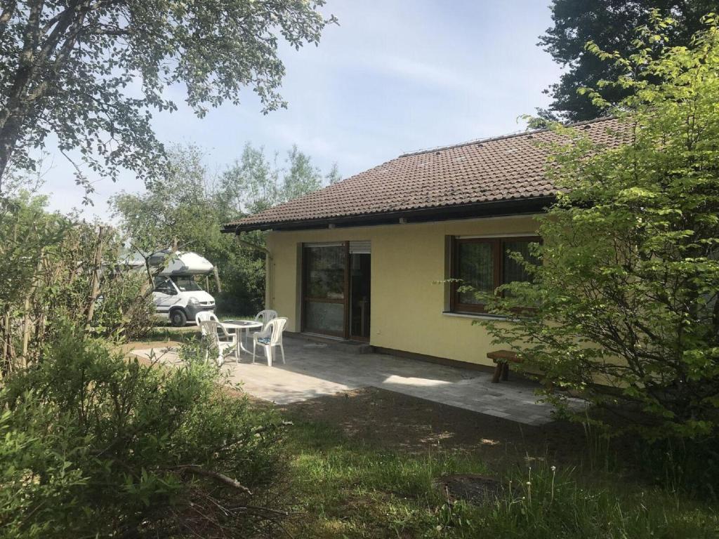 una pequeña casa amarilla con mesa y sillas en Feriendorf Reichenbach - Wieselweg 1 en Nesselwang