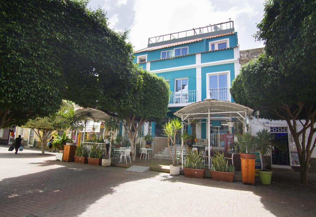 een blauw gebouw met bomen ervoor bij Hotel Santa Maria in Praia