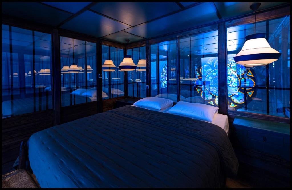 A bed or beds in a room at La Chapelle du Carmel - Centre ville - 340 M2 - SPA - Cinéma - Parking -