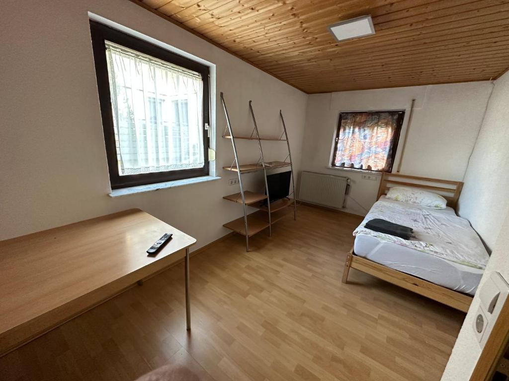 1 dormitorio con cama, escritorio y ventana en HW1 Drei Zimmer Wohung 80qm, en Königsbronn