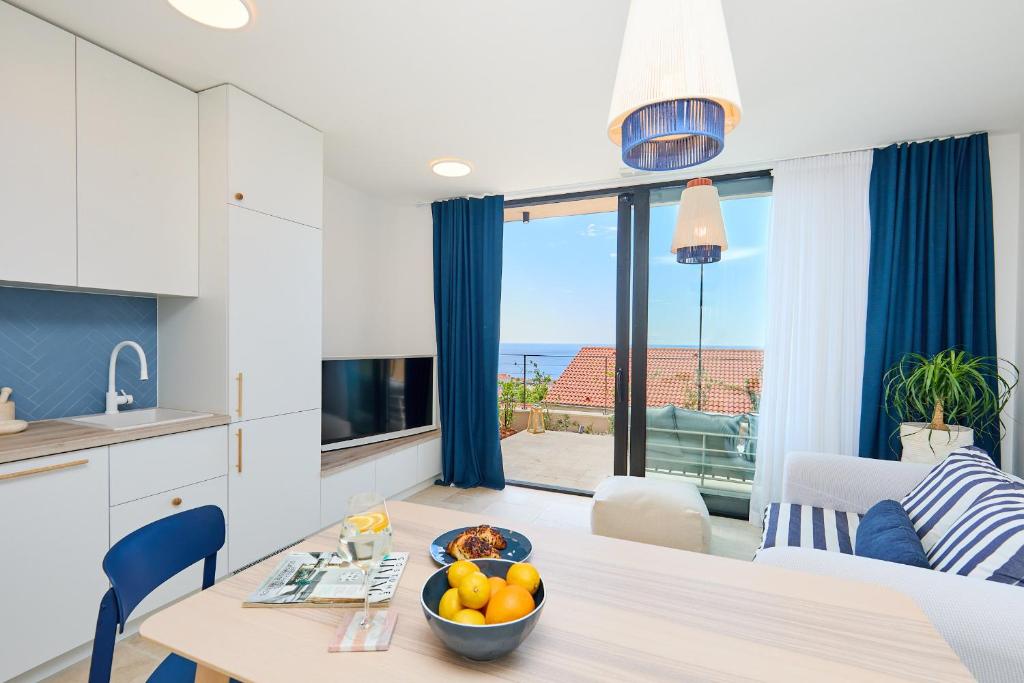 eine Küche und ein Wohnzimmer mit einem Tisch und einer Obstschale in der Unterkunft Hedera Estate Hedera Studio 1 in Dubrovnik