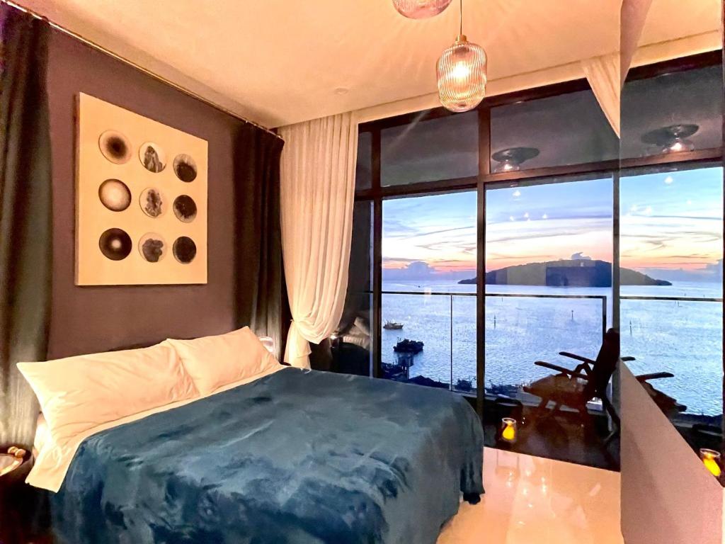 a bedroom with a bed and a large window at Seaview Bliss Studio By Tropical Elegance in Kota Kinabalu