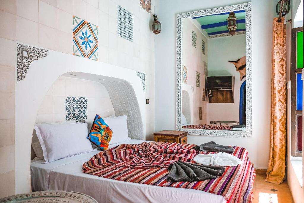 a bedroom with a bed with a large mirror at Héritage Lalla Aicha Hotel & Spa in Marrakesh