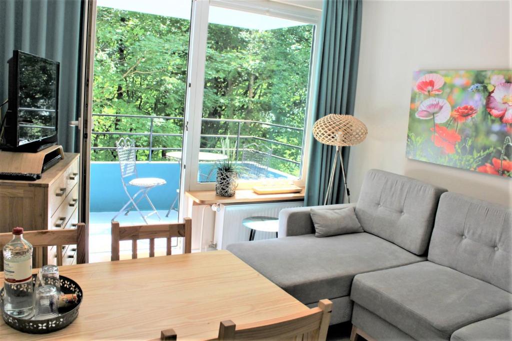 a living room with a couch and a table at Sandwig-Lodge in Glücksburg