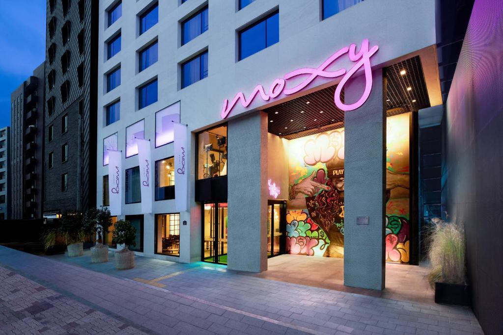 a store with a neon sign on the side of a building at Moxy Seoul Insadong in Seoul