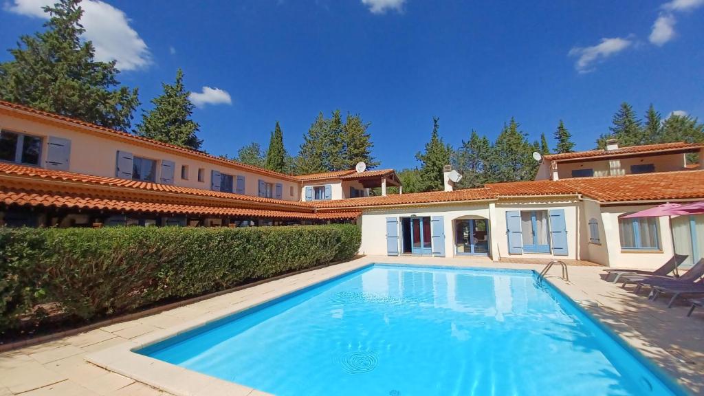 a large swimming pool in front of a house at Hôtel Bel Valen in Le Val