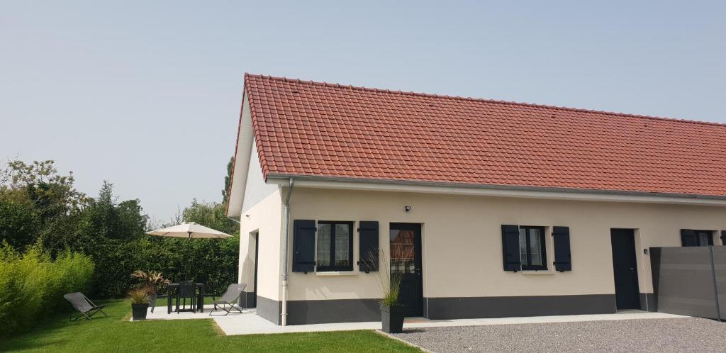 una pequeña casa blanca con techo rojo en Gites Les Mondaines - Les hirondelles, en Favières