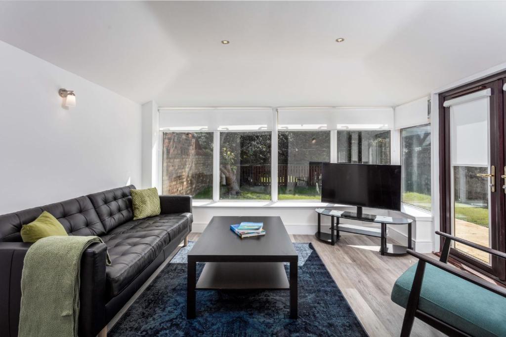 a living room with a couch and a flat screen tv at St Meddans Mews - Donnini Apartments in Troon