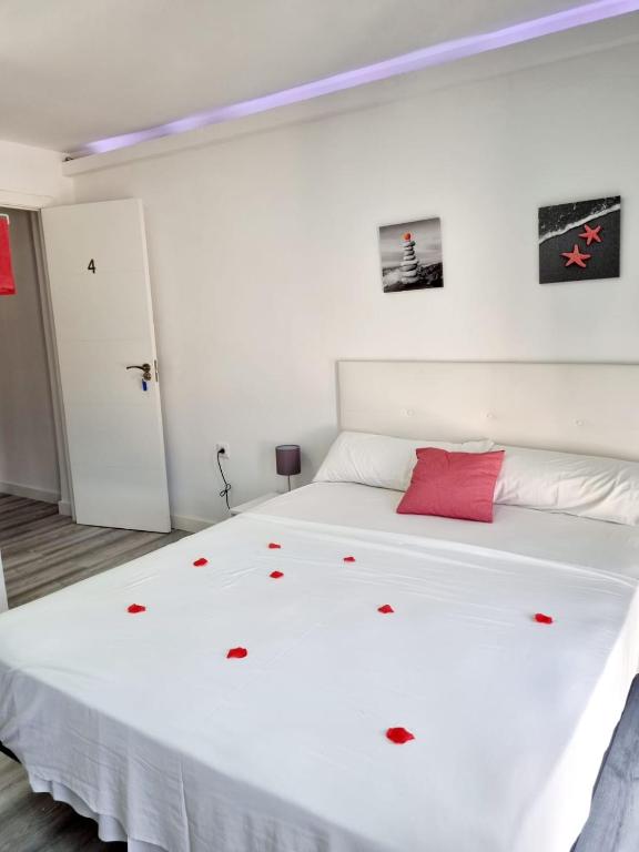 1 dormitorio con cama blanca y almohada roja en Apartamentos T5 Valencia, en Torrent